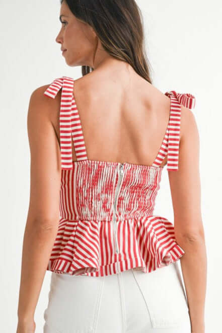 Back view of a chic red and white striped peplum top with tie straps, showcasing a flattering silhouette and flared hem.