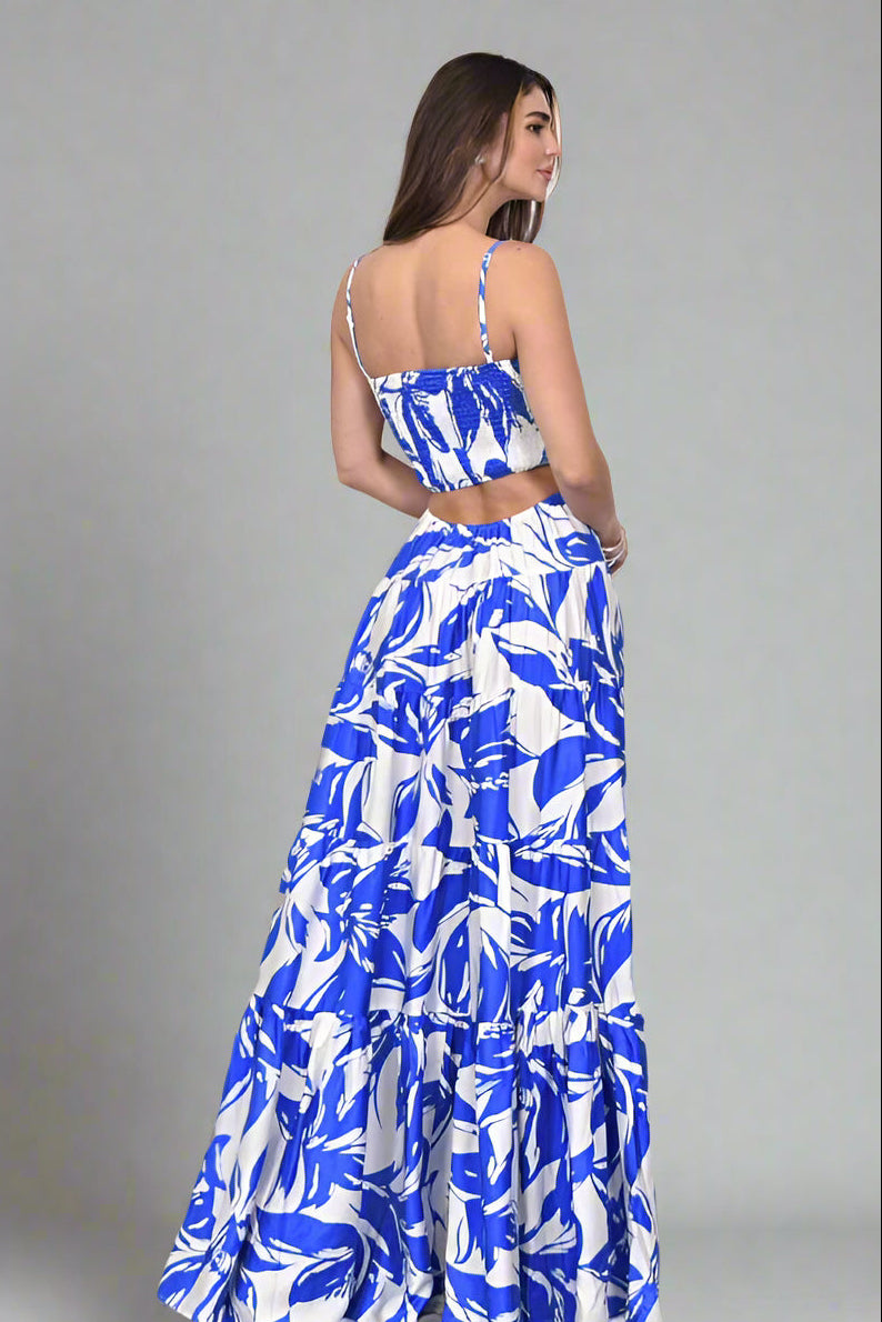 Back view of a woman wearing a Floral Printed Woven Cut Out Maxi Dress in blue and white floral pattern.