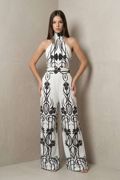 Elegant Sohana Jumpsuit with high halter neckline, fitted waist, wide-leg, and black-and-white botanical print.