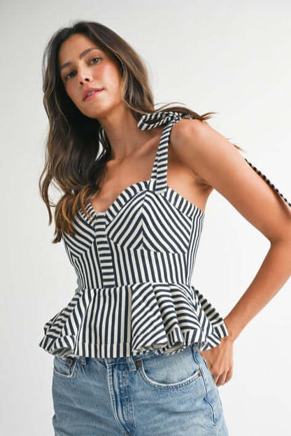 Chic striped peplum top with sweetheart neckline and flared hem, styled with denim shorts.