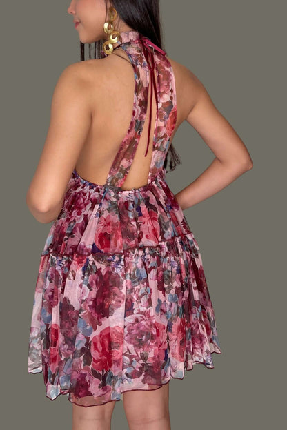 Elegant floral halter mini dress with an open back and tiered skirt, perfect for sunny days and special occasions.